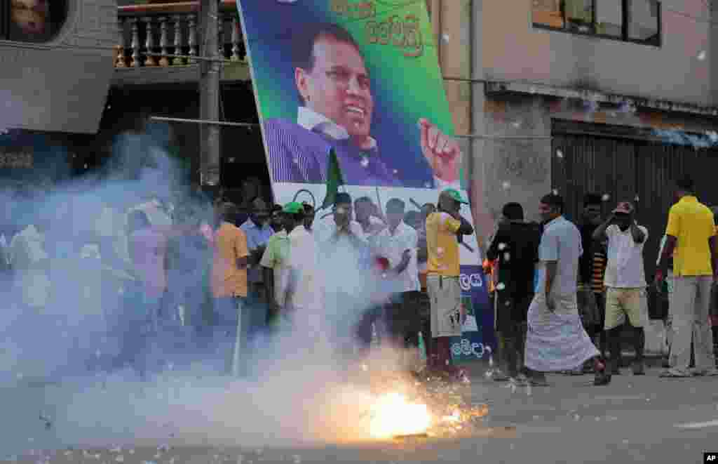 Supporters of Sri Lanka's main opposition presidential candidate Maithripala Sirisena set off firecrackers in front of his campaign poster at the end of voting in Colombo, Sri Lanka, Jan. 8, 2015. 
