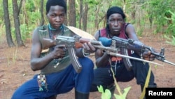 Des combattants de l'Armée de résistance du Seigneur posent avec leurs fusils à l'intérieur de la forêt près de la rivière Mbou en République centrafricaine, 4 avril 2012.