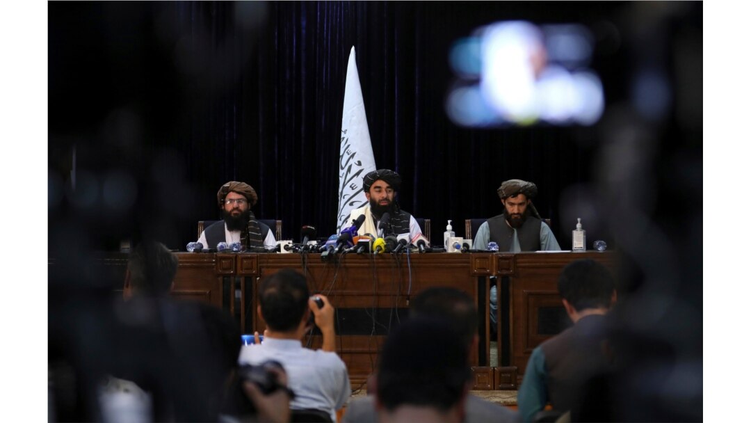 Taliban spokesman Zabihullah Mujahid, center, speaks at his first news conference in Kabul, Afghanistan, Aug. 17, 2021.