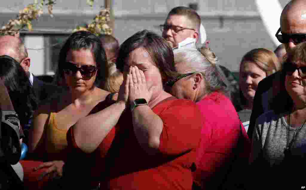 Laura Smith, center, holds her head in her hands during the 85 seconds of silence to honor the 85 people who died in last year's Camp Fire during ceremonies in Paradise, Calif., Nov. 8, 2019.