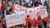 FILE - People hold placards and banners during a demonstration called by far-right and COVID-19 deniers to protest restrictions related to the coronavirus pandemic, in Berlin, Aug. 29, 2020.