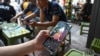 FILE - A man looks at the social media platform TikTok on his smartphone in Hanoi, Vietnam, Oct. 6, 2023. New internet rules requiring Facebook and TikTok to verify user identities and hand over data to authorities came into force on Dec. 25, 2024.