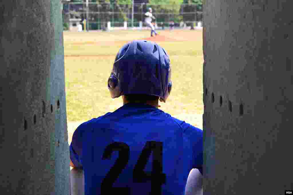 Cuban baseball player watches from the bench in Havana, Cuba. (R. Taylor / VOA)
