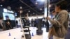 FILE - People check out the Pudu delivery robots at the Pudu booth during the CES tech show, Jan. 8, 2020, in Las Vegas. 