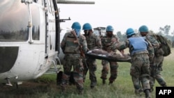 Des membres du bataillon indien de la Monusco transportent un blessé après des combats à Kiwanja en RDC entre les rebelles M23 et et l'armée congolaise le 28 juillet 2012.