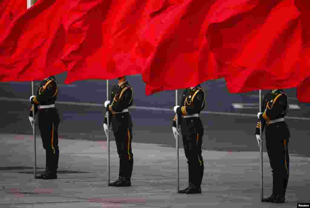 Soldiers of the People's Liberation Army's guard of honor hold flags in front of Beijing's Tiananmen Square during the official welcoming ceremony for Serbian President Tomislav Nikolic outside the Great Hall of the People.