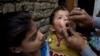 FILE - A Pakistani health worker gives a polio vaccine to a child in Islamabad, Dec. 8, 2014.