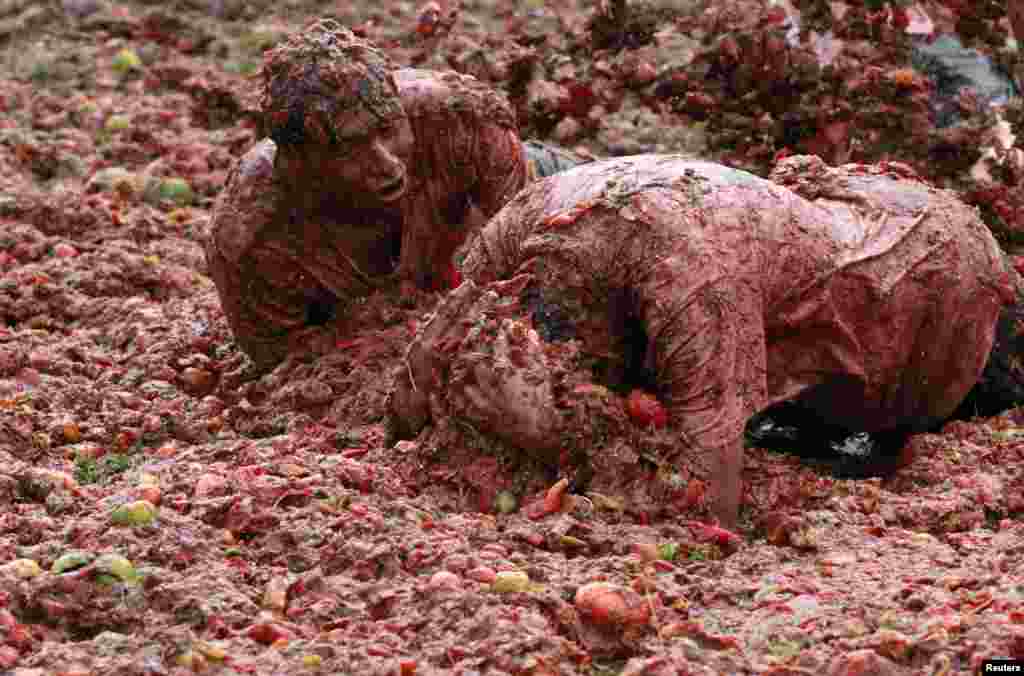 Revelers play with tomato pulp during the annual "Tomatina" (tomato fight) in Sutamarchan province in Boyaca, Colombia, June 2, 2013.