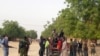 Local volunteers carrying weapons stand in the Jiddari Polo area in Maiduguri, Nigeria, after an attack by Boko Haram militants, April 27, 2018.