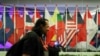 FILE - A journalist walks past ASEAN member country flags at the Suntec Convention Centre during the 33rd ASEAN summit in Singapore, Monday, Nov. 12, 2018. (AP Photo/Yong Teck Lim)