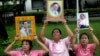 Thais hold portraits of Thai King Bhumibol Adulyadej at Siriraj Hospital where the king is being treated in Bangkok, Thailand, Oct. 11, 2016. 