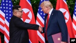 도널드 트럼프 미국 대통령과 김정은 북한 국무위원장이 지난해 6월 싱가포르에서 첫 정상회담을 마친 후 악수하고 있다.
