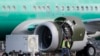 FILE - A worker walks past an engine on a Boeing 737 MAX 8 airplane being built for American Airlines at Boeing Co.'s Renton assembly plant, March 13, 2019, in Renton, Wash.