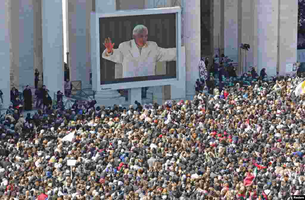 Pope Benedict appears on a giant screen in a packed St. Peter's Square at the Vatican during his last general audience, February 27, 2013.