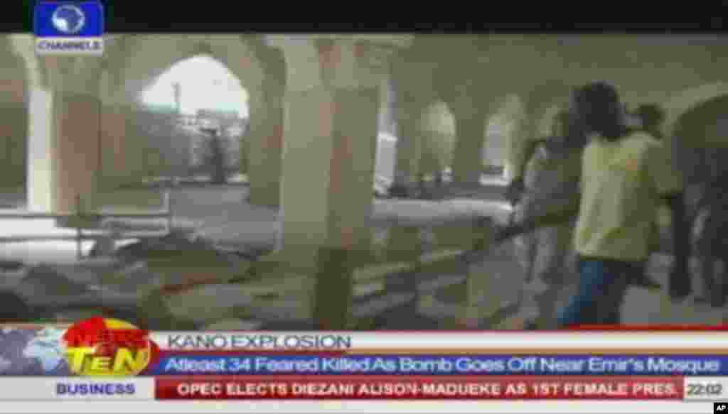 Une image fixe d'un programme de la chaîne de télé NTA montre des personnes inspectant l'intérieur d'une mosquée après des explosions qui ont tué au moins 35 personnes, selon la police, le vendredi 28 novembre 2014, à Kano, au Nigeria . (AP Photo / NTA / Chaînes TV)