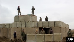 Pasukan keamanan Afghanistan berjaga di pos terdepan Tentara Nasional Afghanistan (ANA) setelah serangan oleh militan Taliban, di Provinsi Kunduz, 4 Maret 2020. (Foto: STR / AFP)