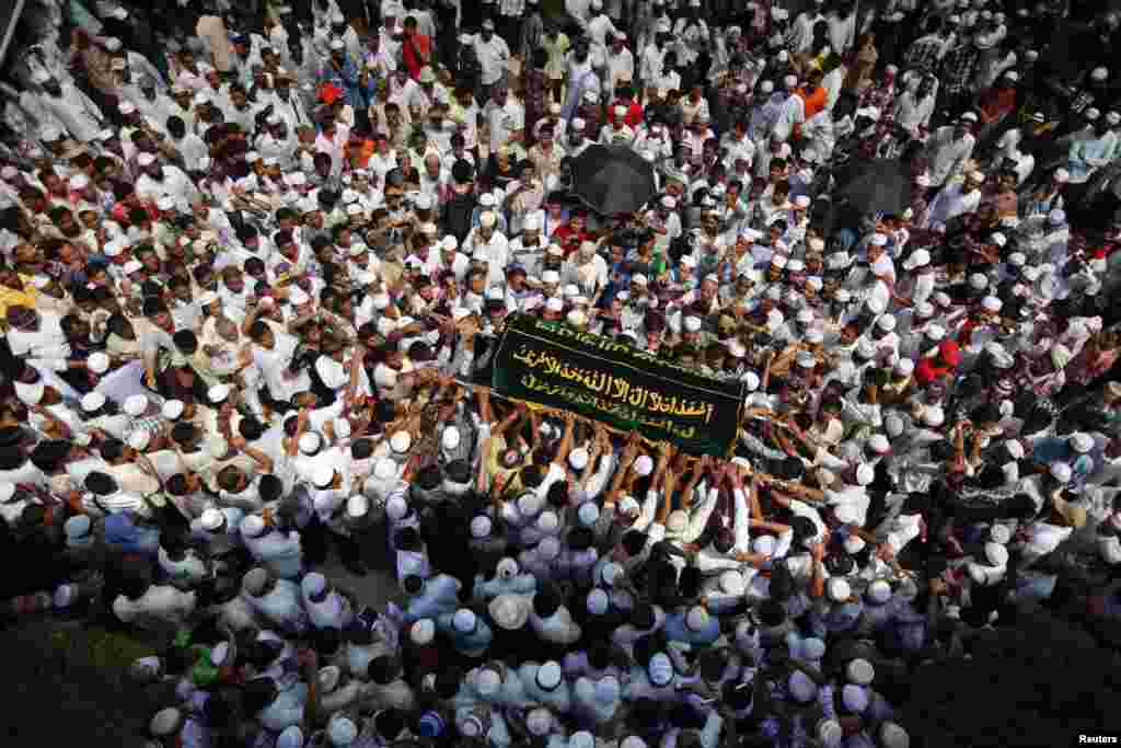 People carry a coffin during the funeral for victims of a fire at Yaeway cemetery, Rangoon, Burma, April 2, 2013.