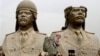 FILE - U.S. soldiers walk past two gigantic status of former Iraqi President Saddam Hussein in Baghdad, March 20, 2009.