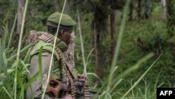 Un soldat des FARDC (Forces Armées de la République démocratique du Congo) prend position lors d'échanges de tirs avec des membres de l'ADF (Forces Démocratiques Alliées) à Opira, Nord Kivu, 25 janvier 2018.