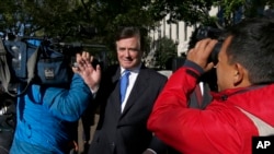 FILE - Paul Manafort makes his way through television cameras as he walks from Federal District Court in Washington, Oct. 30, 2017. 