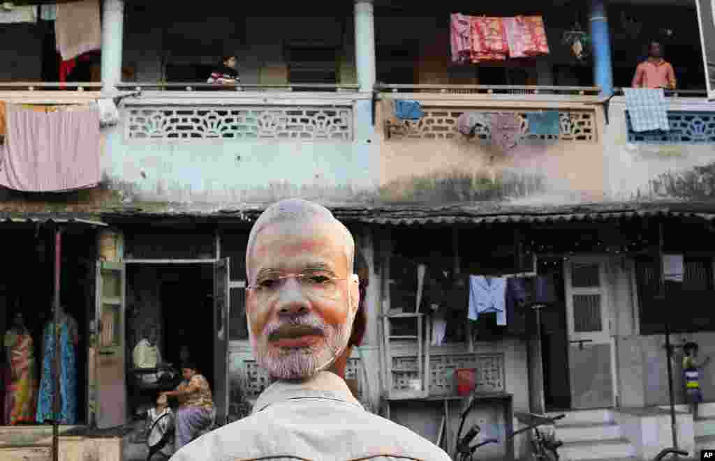 A supporter of India's main opposition Bharatiya Janata Party wears a mask depicting the face of Prime Minister candidate Narendra Modi, during an election rally in Mumbai, April 9, 2014.