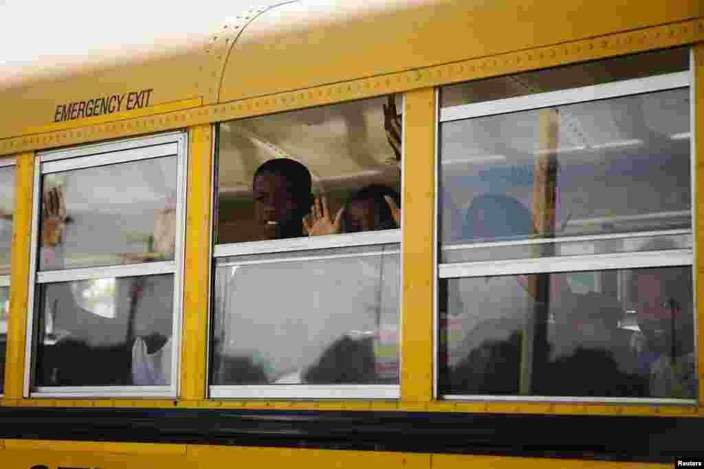 A school bus full of children chant, "Hands up, don't shoot" as the vehicle drives past the scene where St. Louis Metropolitan Police earlier shot and killed a man wielding a knife in the St. Louis area, August 19, 2014.