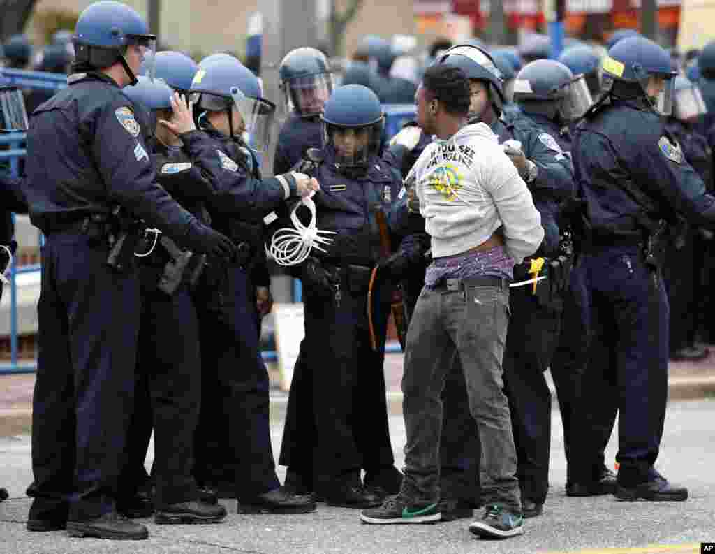 Polisi menahan seorang pria setelah berbaris menuju balai kota untuk Freddie Gray di Baltimore (25/4). (AP/Alex Brandon)