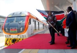 FILE - Kenya's President Uhuru Kenyatta flags off the train linking Nairobi and Naivasha at the Nairobi Terminus on the outskirts of Nairobi, Oct. 16, 2019.