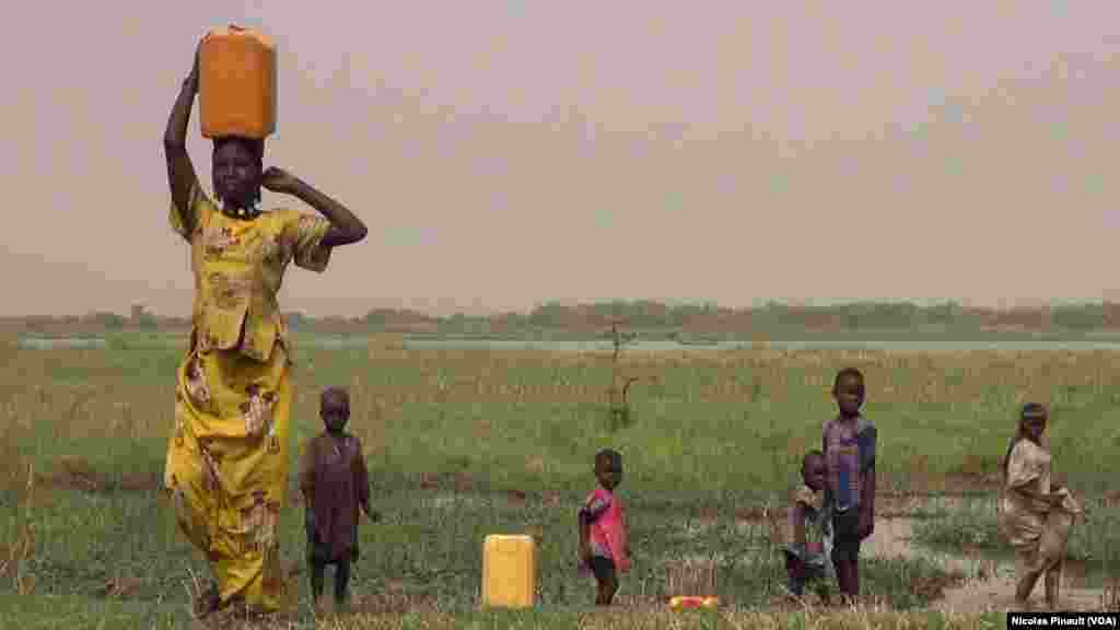 Une jeune femme porte un bidon d'eau au bord du lac Tchad, Tagal, Tchad, le 24 avril 2017 (VOA/Nicolas Pinault)