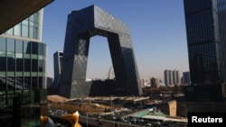 Mobil-mobil melintas di depan kantor pusat CCTV, media resmi pemerintah China dan stasiun TV berbahasa Inggris, CGTN, di Beijing, China, 5 Februari 2021. (Foto: Carlos Garcia Rawlins/Reuters)