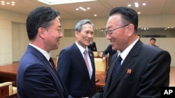 南韓統一部部長官永康杓（左）和一位負責南韓事務的北韓官員（右）握手（2015年8月25日）。