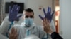 Le physiothérapeute espagnol Vicente Barrios s'entraîne avec le premier résident infecté par le coronavirus et guéri, dans une maison de retraite pour personnes âgées à Madrid le 24 avril 2020. (Photo de OSCAR DEL POZO / AFP)