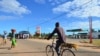 FILE - A man bikes past a gas station, June 11, 2018, in Macomia, Northern Mozambique. Cabo Delgado, a northern province expected to become the center of a natural gas industry, has seen a string of assaults on security forces and civilians since October.