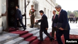 Menlu AS John Kerry (kanan) tiba di Istana Presiden Afghanistan di Kabul, didampingi oleh Dubes AS untuk Afghanistan James Cunningham (dua dari kanan) dan Kepala Protokoler kementerian Luar Negeri Afghanistan Hamid Siddiq (tengah), 12 Oktober 2013.