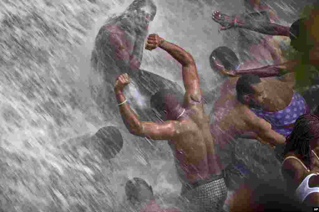 Voodoo pilgrims bathe in a waterfall believed to have purifying powers during the annual celebration in Saut d' Eau, Haiti, July 16, 2014