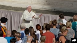 Pope Francis asks the faithful to keep safety distance as he arrives during his weekly general audience in San Damaso courtyard at the Vatican, Wednesday, Sept. 9, 2020. (AP Photo/Andrew Medichini)