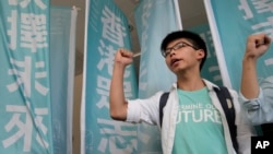 Remaja pemimpin unjuk rasa Joshua Wong meneriakkan slogan-slogan di pengadilan di Hong Kong (21/7). (foto: AP Photo/Vincent Yu)