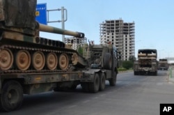 FILE - A convoy of Turkish military trucks carrying tanks destined for Syria, moves near the town of Kilis, Turkey,Sept. 14, 2018.