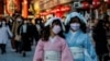Visitors wearing protective face masks walk under decorations for the New Year at Nakamise street leading to Senso-ji temple at Asakusa district, a popular sightseeing spot, amid the coronavirus disease (COVID-19) pandemic, in Tokyo, Dec. 24, 2021. 