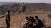 El agente de la Patrulla Fronteriza Gutiérrez camina junto a cuatro hombres detenidos después de cruzar la frontera ilegalmente por un espacio entre dos muros que separan a México de Estados Unidos. [Foto:Archivo/AP]