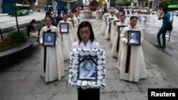 Potret-potret perempuan Korea yang dijadikan budak seks oleh tentara Jepang pada Perang Dunia II, dalam upacara di Seoul, Agustus 2013. (Reuters/Kim Hong-Ji)