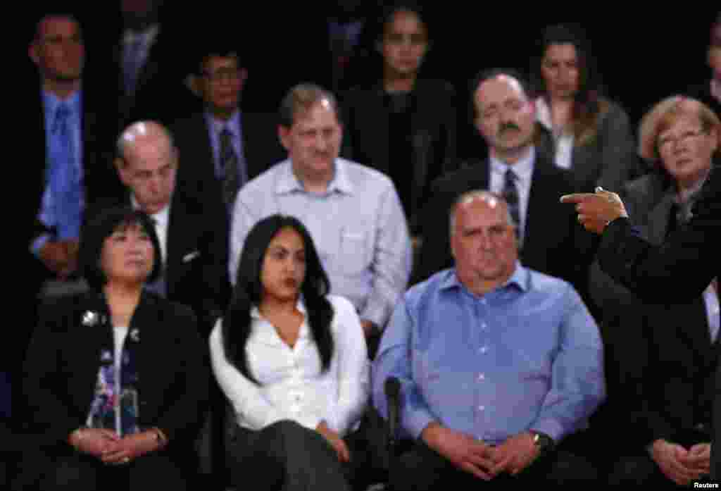 Members of the audience look on as U.S. President Barack Obama (R) speaks as he debates Republican presidential nominee Mitt Romney during the second U.S. presidential debate in Hempstead, New York October 16, 2012.