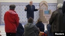 Warga mendengarkan penjelasan Mohamed Latahi (tengah), saat berkunjung di Masjid Besar Strasbourg di Perancis (9/1).