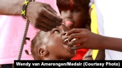 A child is given an oral cholera vaccine dose at the UNMISS Tomping camp in Juba, where tens of thousands of South Sudanese are living in makeshift shelters.