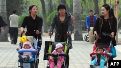 2011年清明节，在北京一个公园里推着婴儿车散步的母亲们。