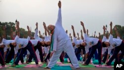 Prime Minister Narendra Modi performs yoga along with thousands of Indians on Rajpath in New Delhi, June 21, 2015.