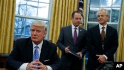 Le président Donald Trump avec son conseiller en charge du commerce, Peter Navarro, et le directeur de cabinet de la maison blanche, Reince Prebius, lors de la signature de trois décrets, le lundi 23 janvier 2017.
