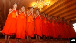 Members of Wild Boars soccer team pray during a ceremony marking the completion of their serving as novice Buddhist monks, following their dramatic rescue from a cave in Mae Sai district, Chiang Rai province, northern Thailand, Aug. 4, 2018.