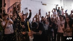 Célébration au champagne devant un bureau de vote pour célébrer après la perte d'un siège favorable à Pékin lors des élections du conseil de district de Hong Kong, début novembre 25, 2019.
