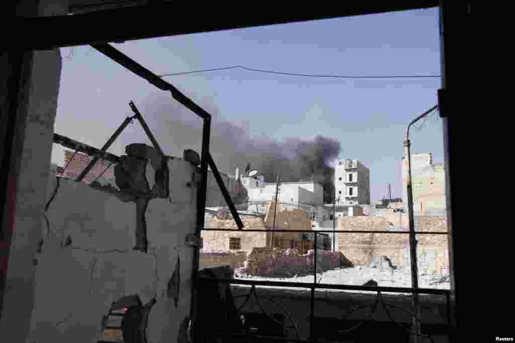 Smoke rises from behind buildings after a shelling at Karm al-Jabal in northeast Aleppo, Syria, October 19, 2012.